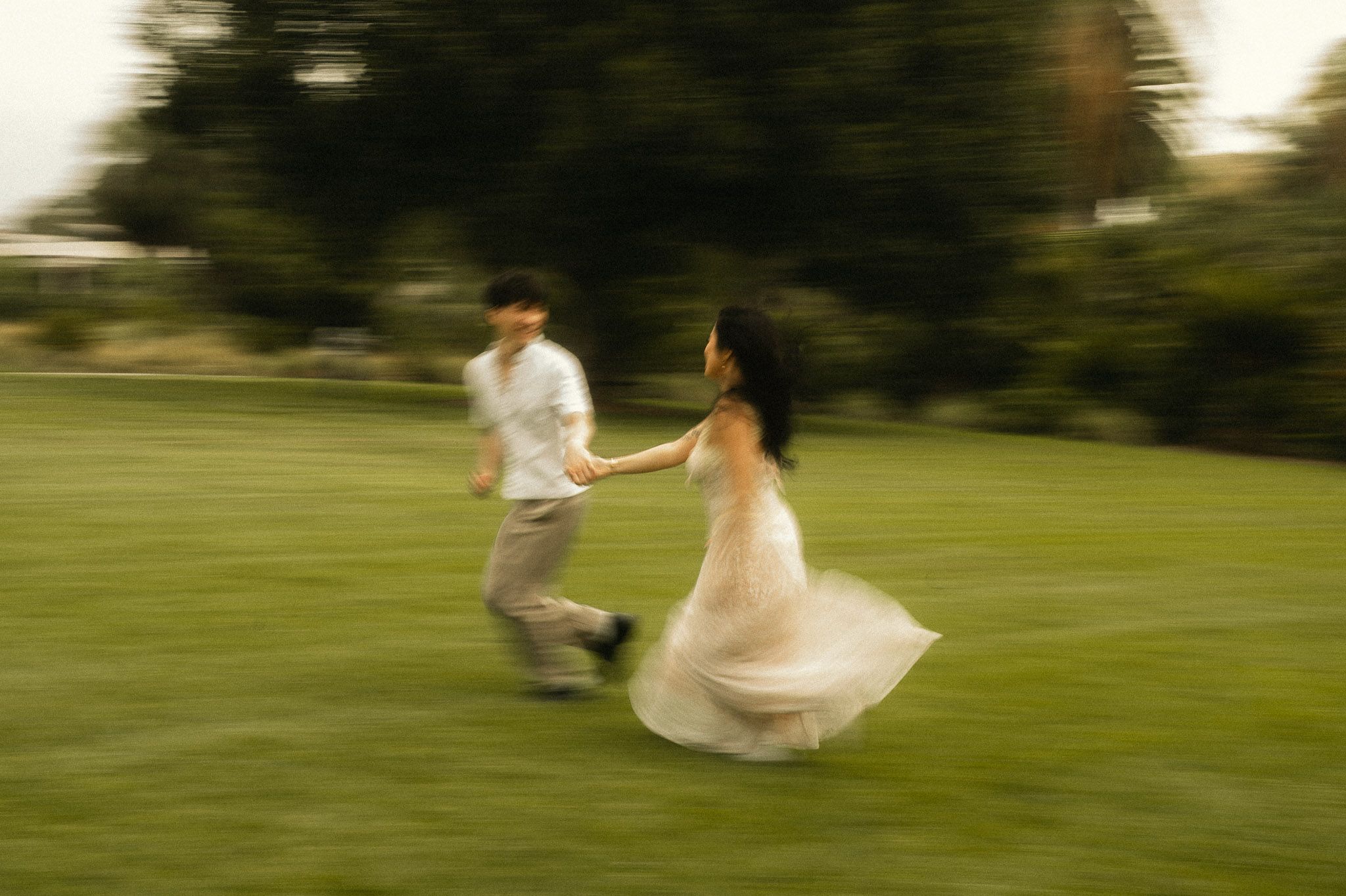 A playful moment as Cindy and Brandon run across the Huntington Library gardens during their engagement photos in San Marino.