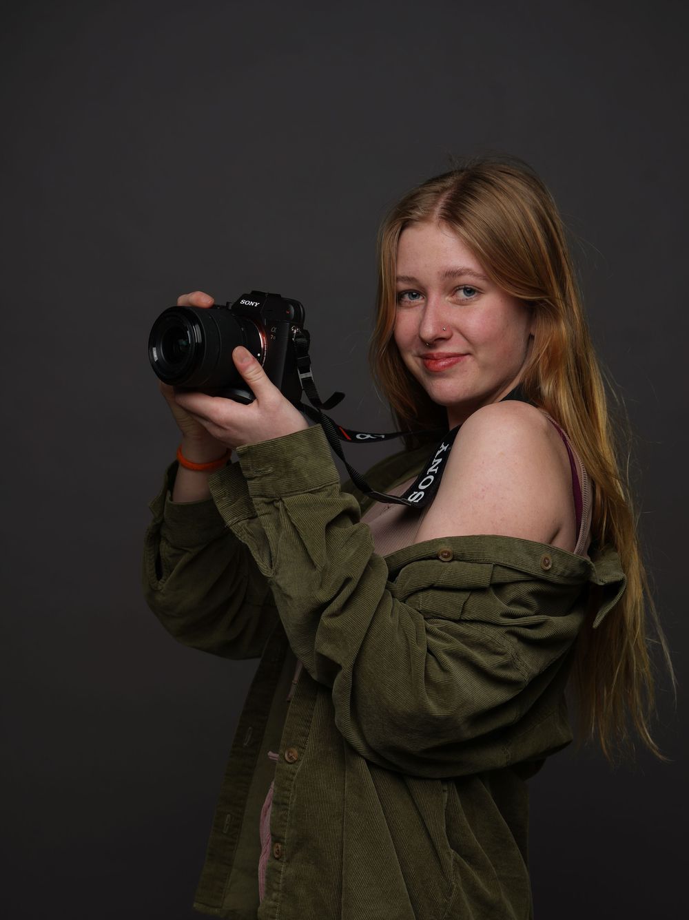 Young female photographer posing with Sony camera.