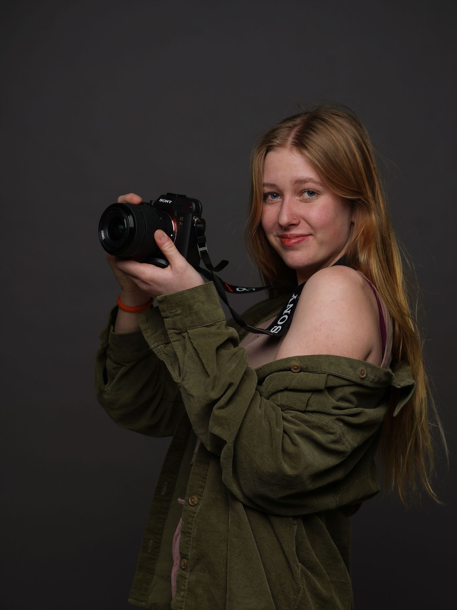 Young female photographer posing with Sony camera.