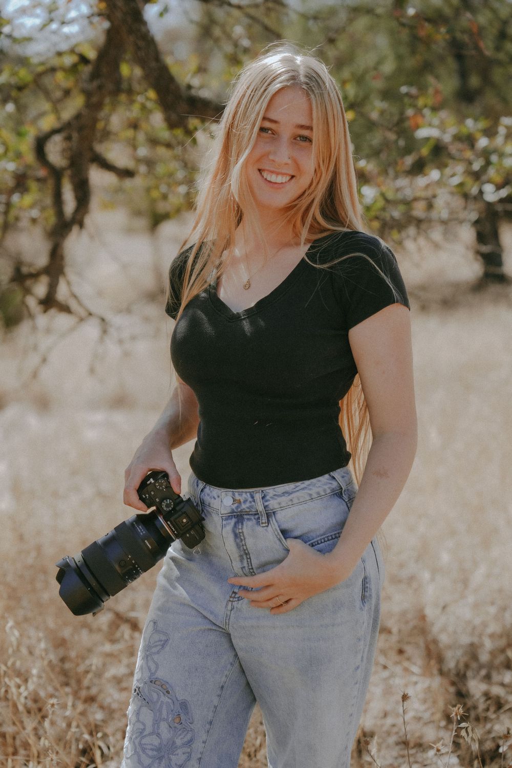 Young female photographer posing with Sony camera.