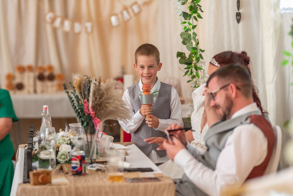 Wedding reception dining room with floral centerpieces and draped fabric decor.