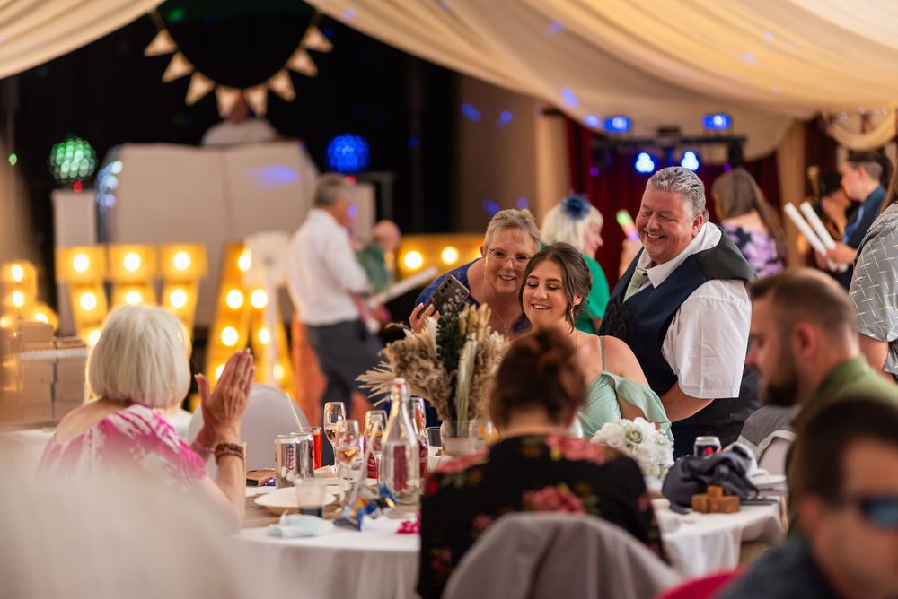Wedding reception venue with warm lighting and guests enjoying the celebration.
