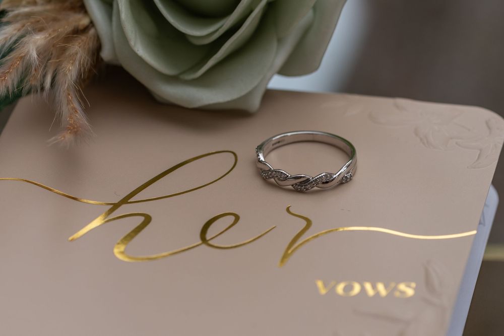 Elegant wedding stationery with gold calligraphy and white rose decoration.