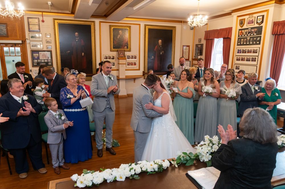 Reception venue with elegant chandeliers and historical decor featuring gathered guests.