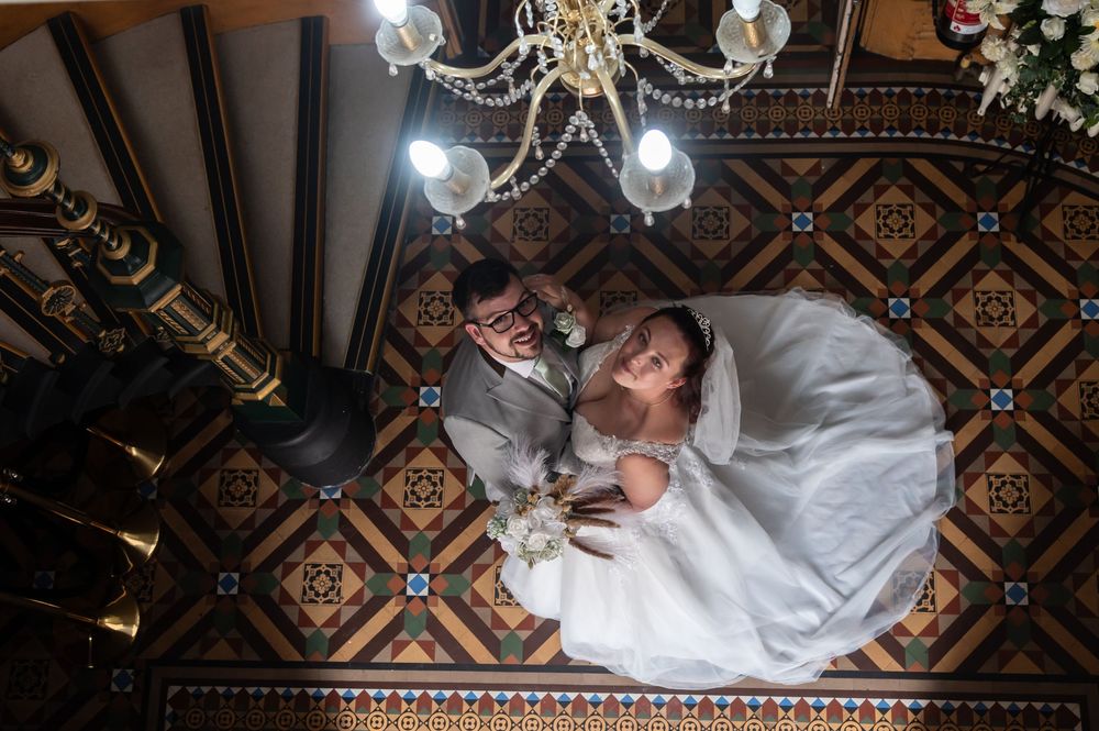 Artistic overhead shot of couple on geometric patterned floor with chandelier lighting.