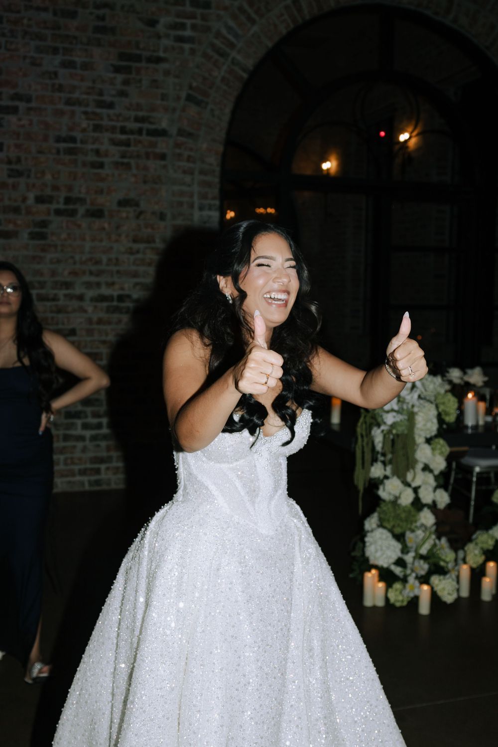Bride in a sparkly white ballgown twirling and dancing joyfully at a reception.