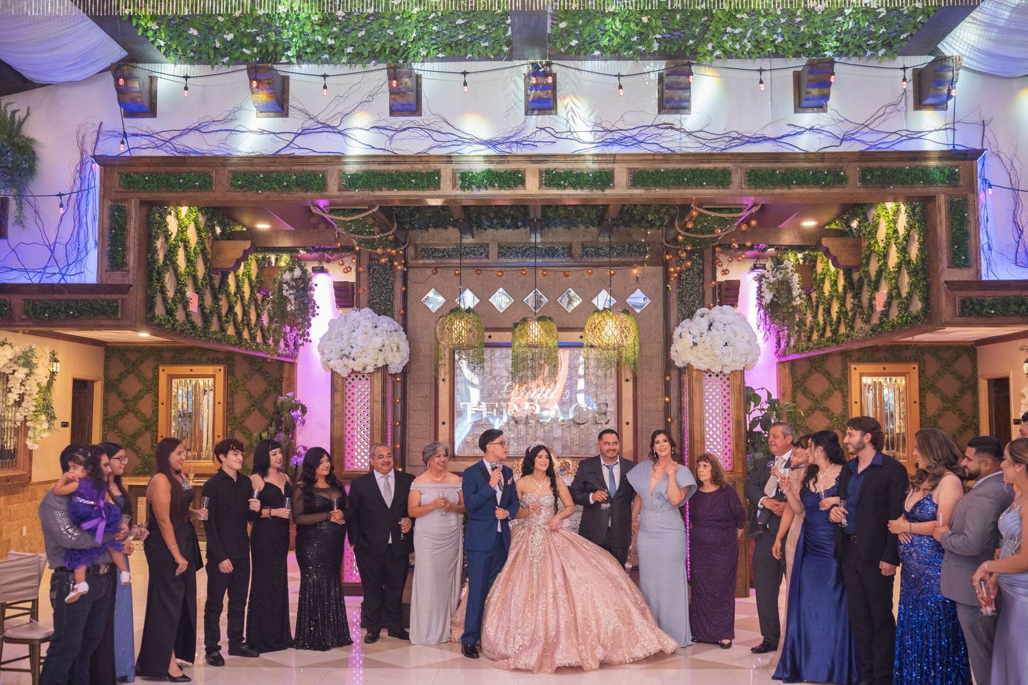 An elegant ballroom celebration with guests in formal attire dancing under crystal chandeliers.