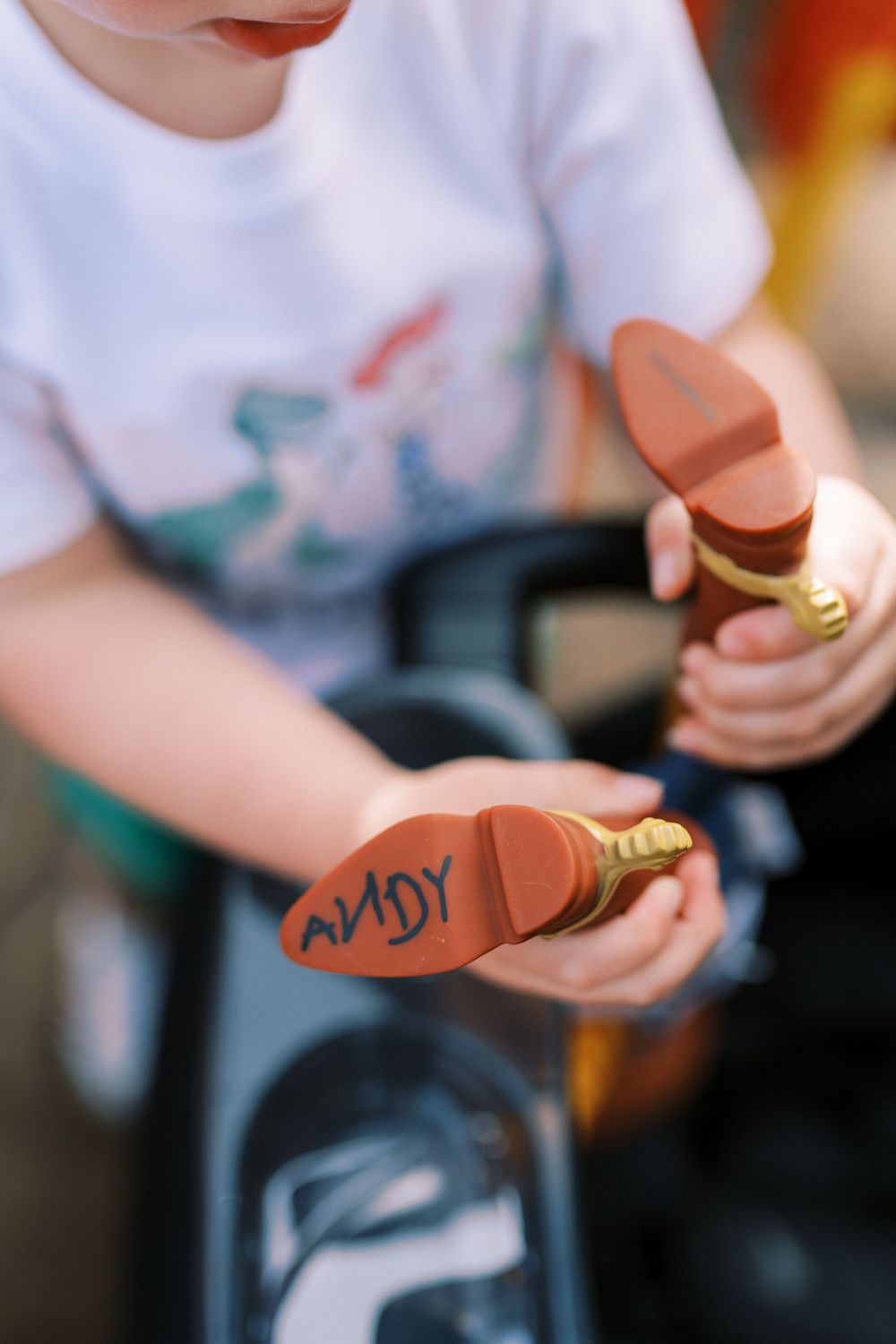 Small hands hold decorative copper-colored iDapt headphone ear tips for custom audio fitting.