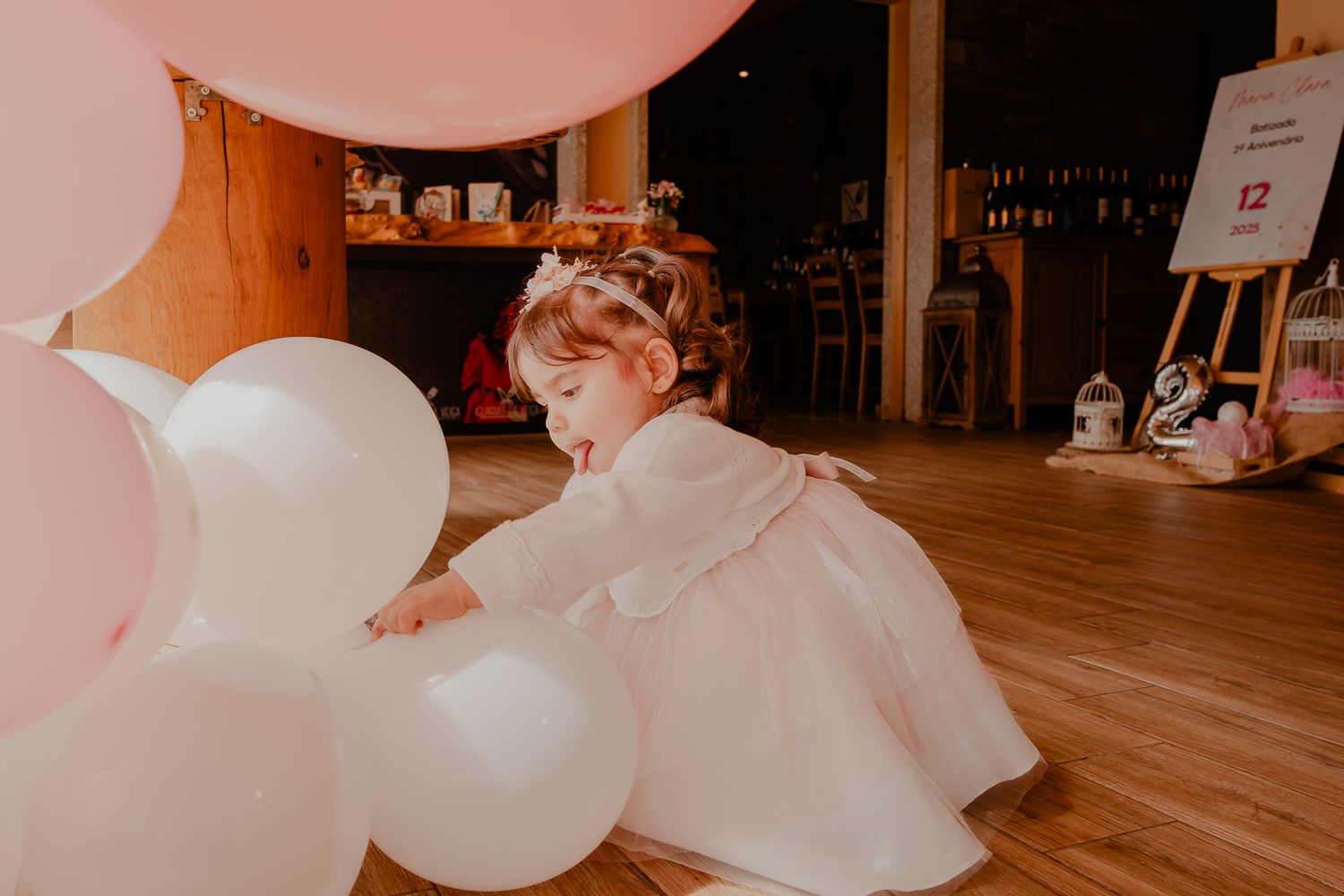 Elegant celebration setup with white balloons and decorative elements in an indoor venue.