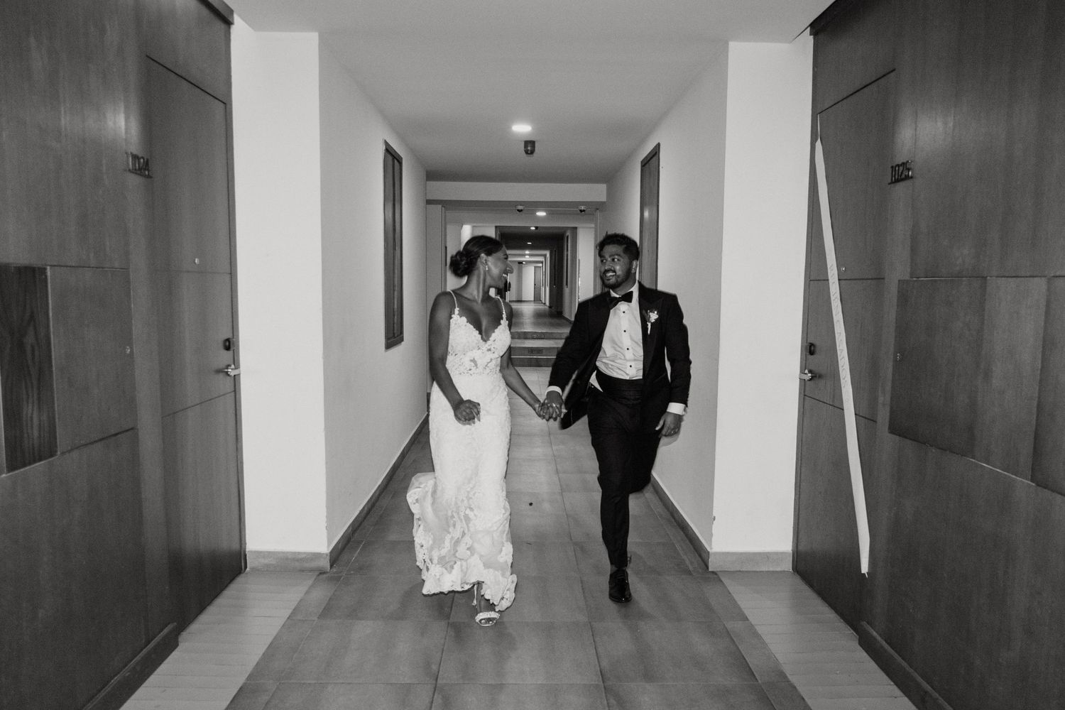 Wedding couple walking down a modern minimalist white hallway.