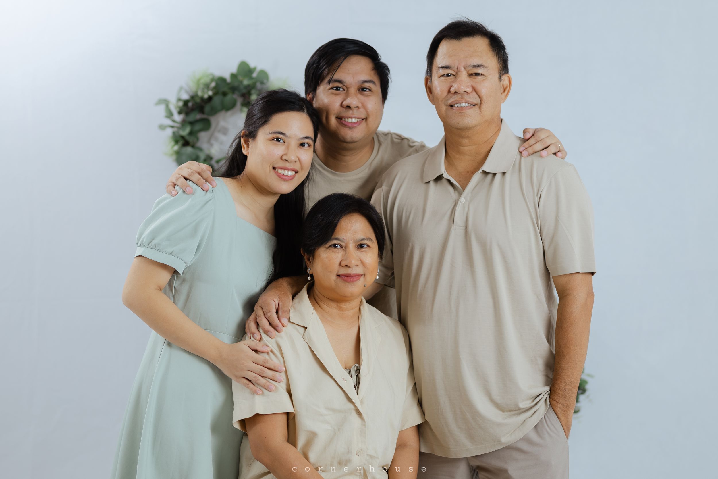 Multi-panel portrait series shows a group in matching light-colored outfits posing together warmly against a neutral background.
