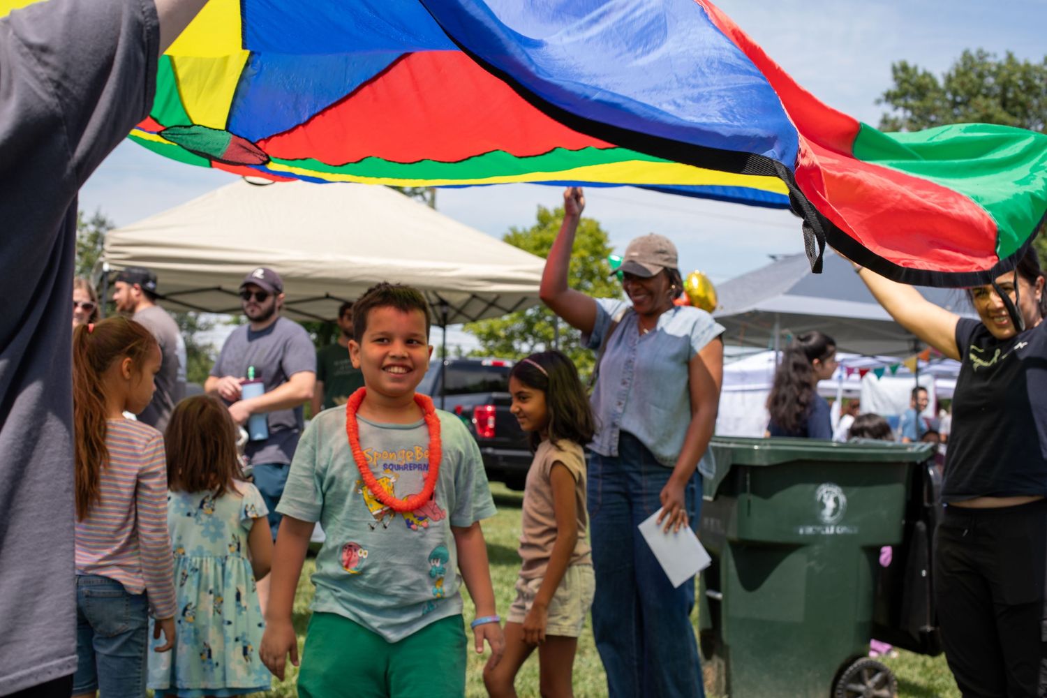 Kidchella Cincinnati family magazine event photo of children playing parachute game at The Little Gym for premium family coverage