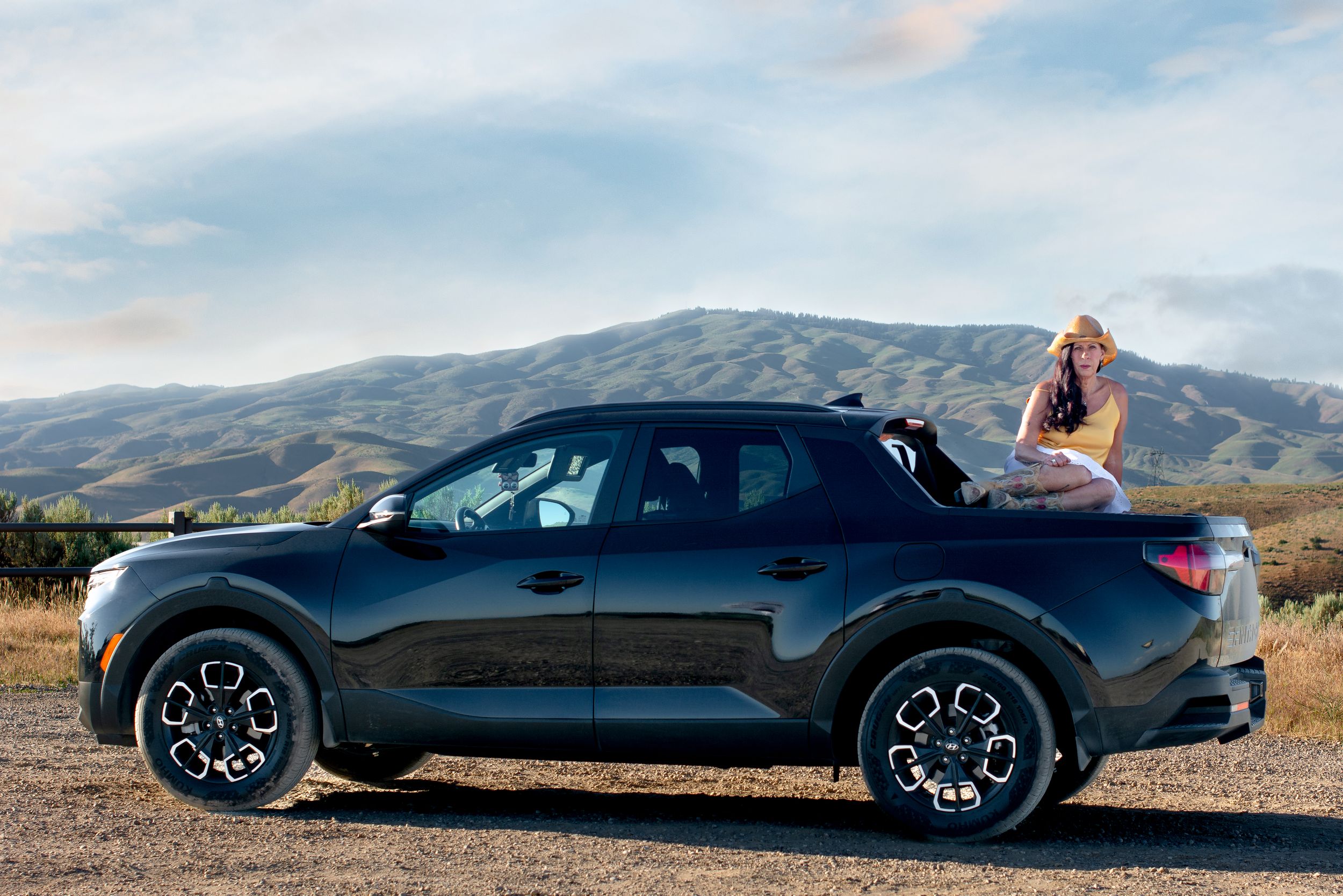 Sleek black sports car photographed against scenic mountain backdrop.