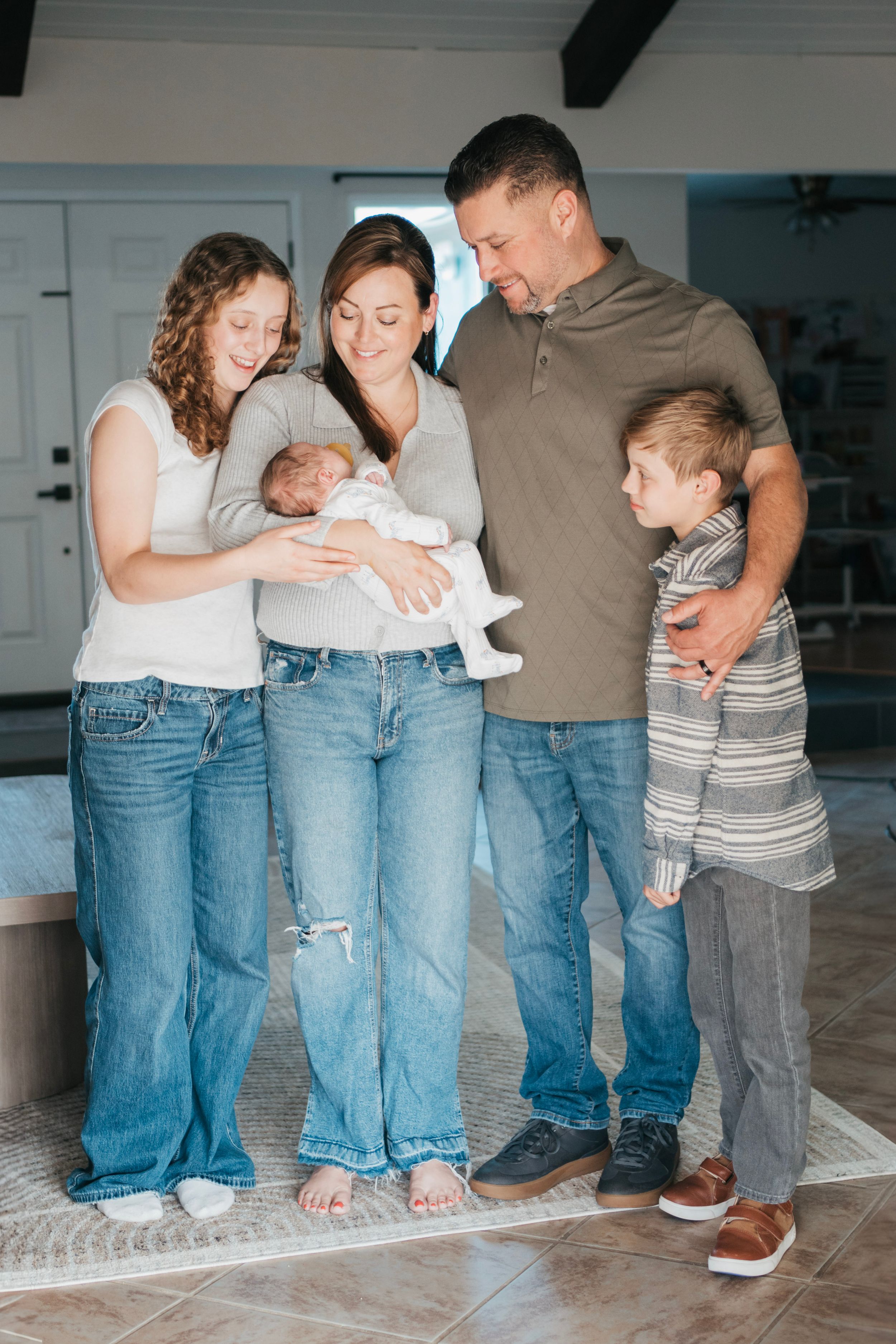 A family of 5 poses for newborn photos in solano county