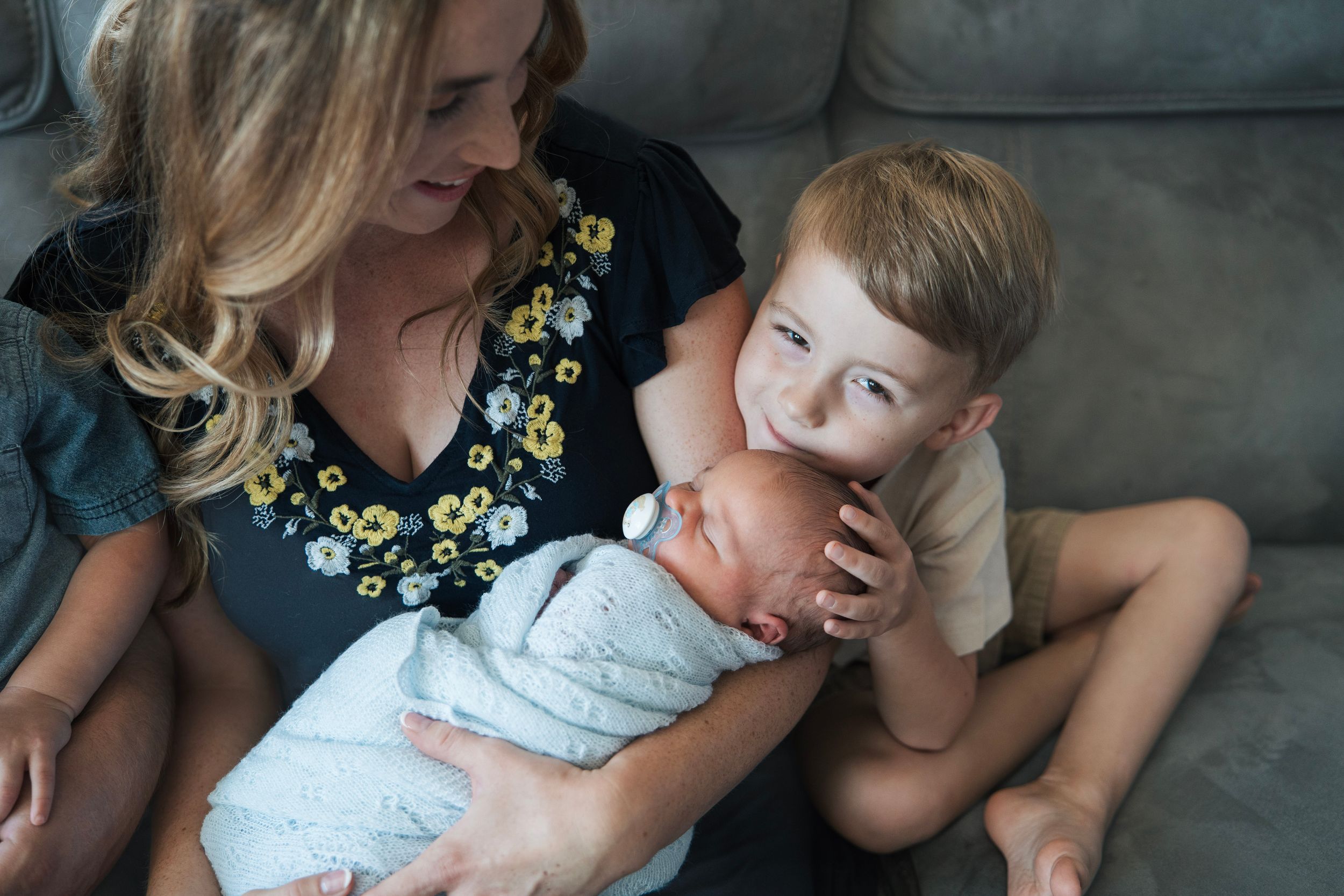 A mom, baby, and toddler pose for family photos with their newborn in solano county