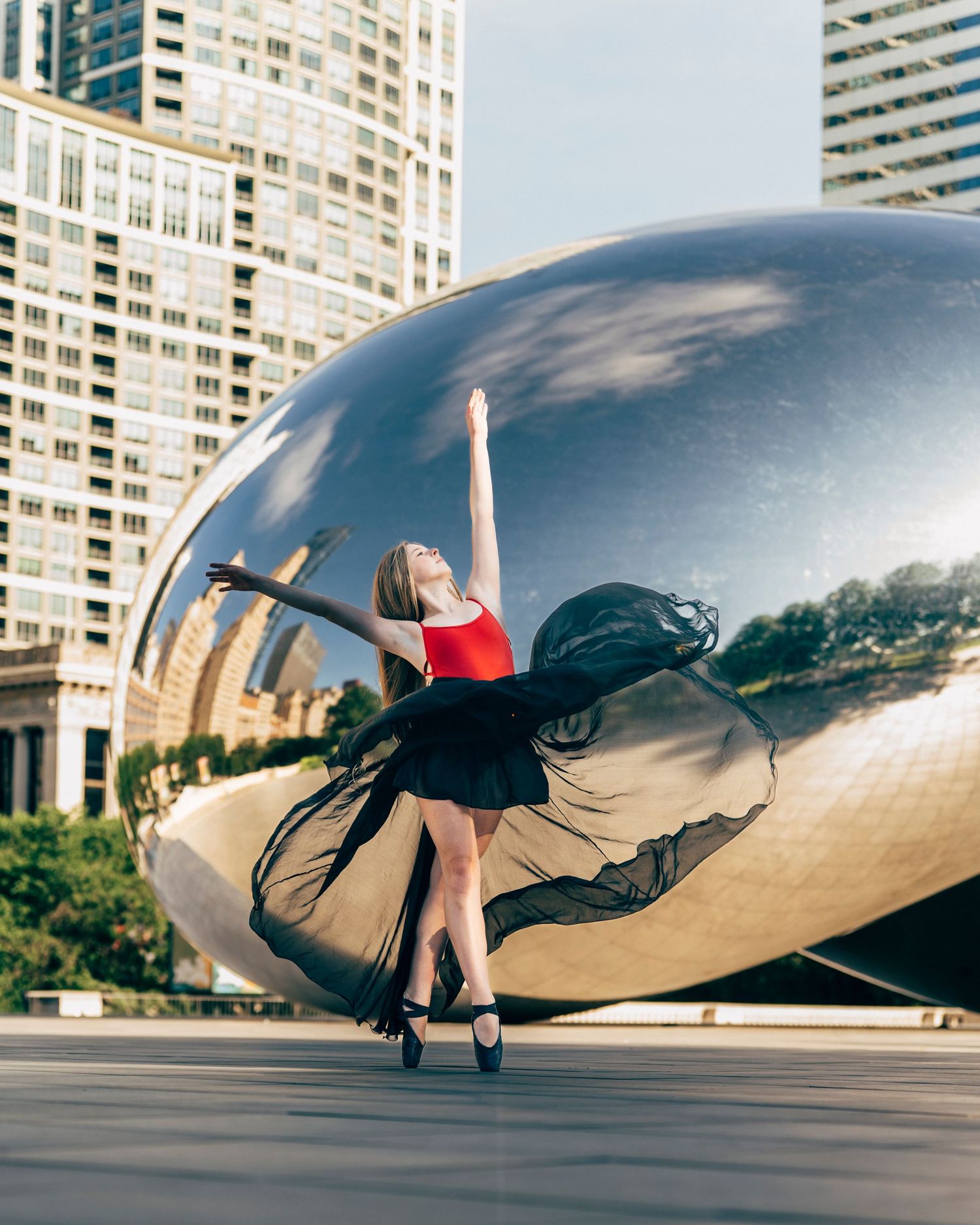 chicago dance photography Young dancer performing posing in Millennium Park with morning light wearing a red leotard and black maxi skirt