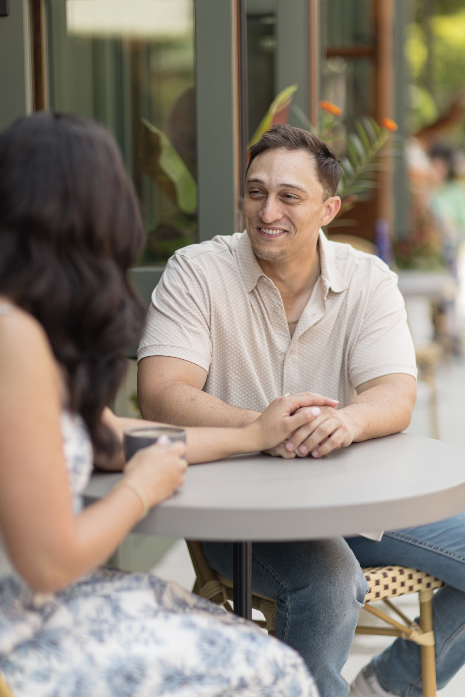 Two people having a casual conversation at an outdoor cafe table.
