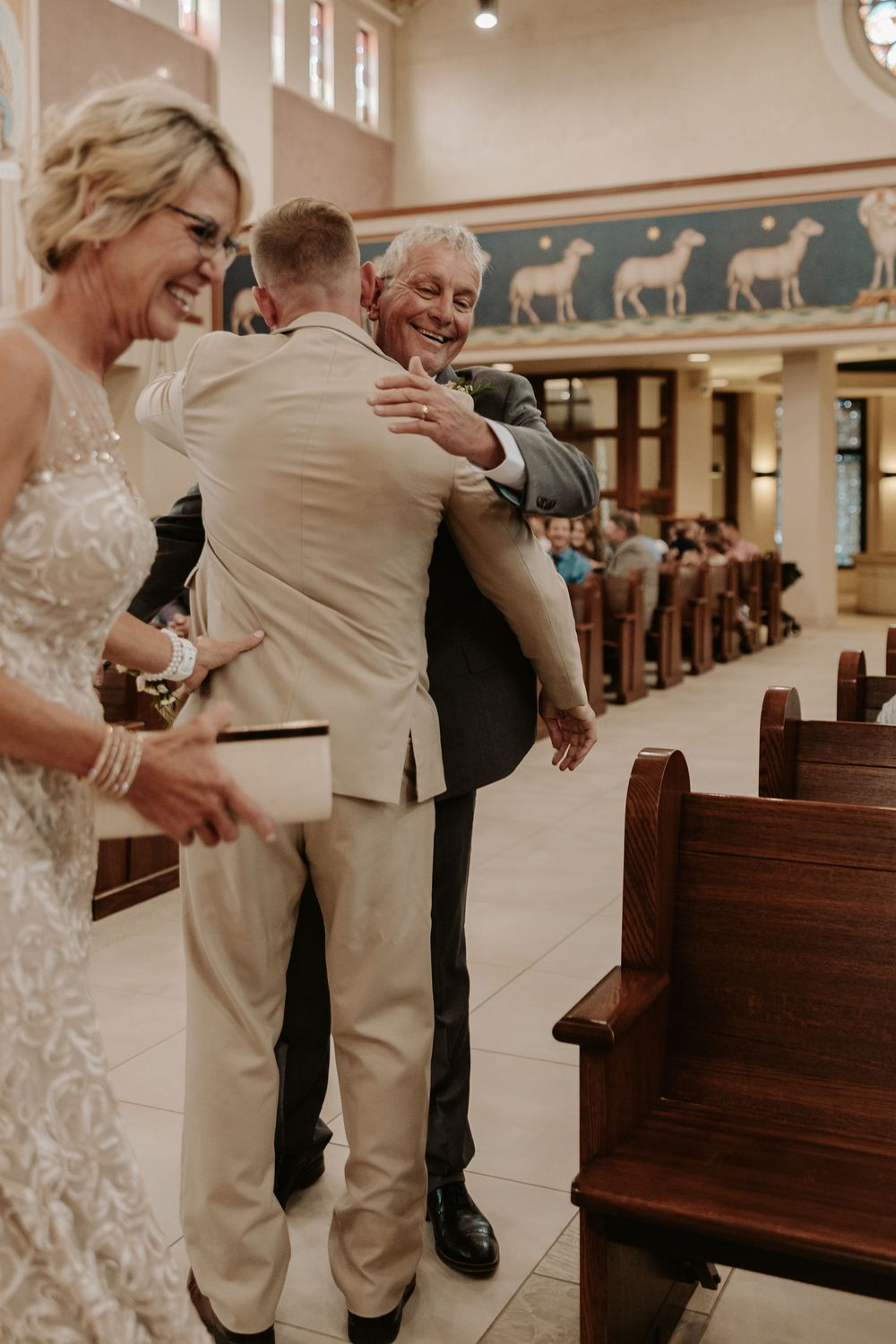 Joyful moments captured inside a church with wooden pews during a wedding celebration.