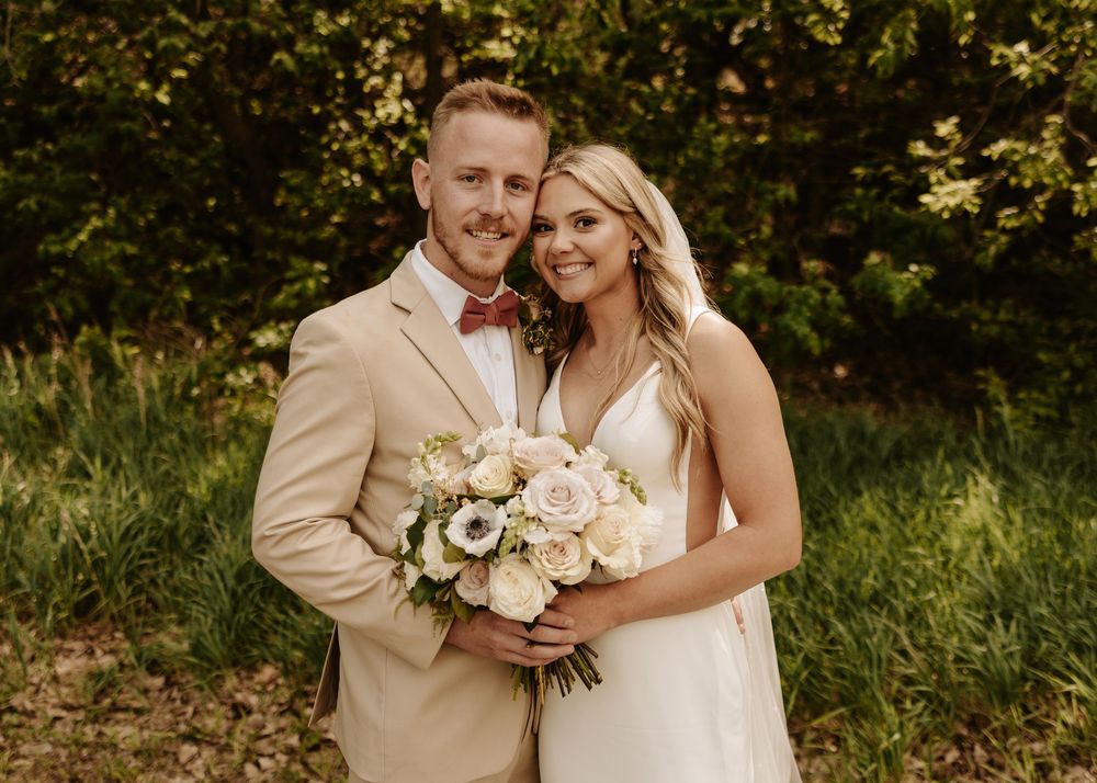 Romantic outdoor wedding portraits with couple posing in natural greenery setting.