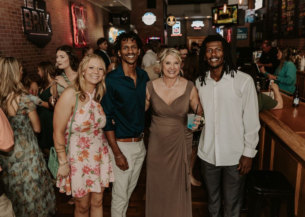A group of friends enjoying themselves at a lively bar with brick walls and ambient lighting.