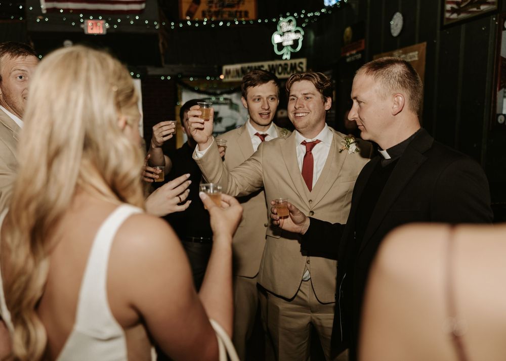 Wedding reception dance floor filled with guests celebrating under string lights.