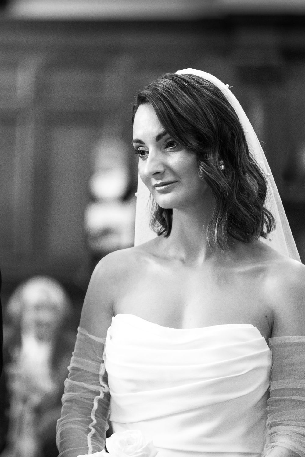 Close-up black and white portrait shots of bride in elegant off-shoulder wedding dress.