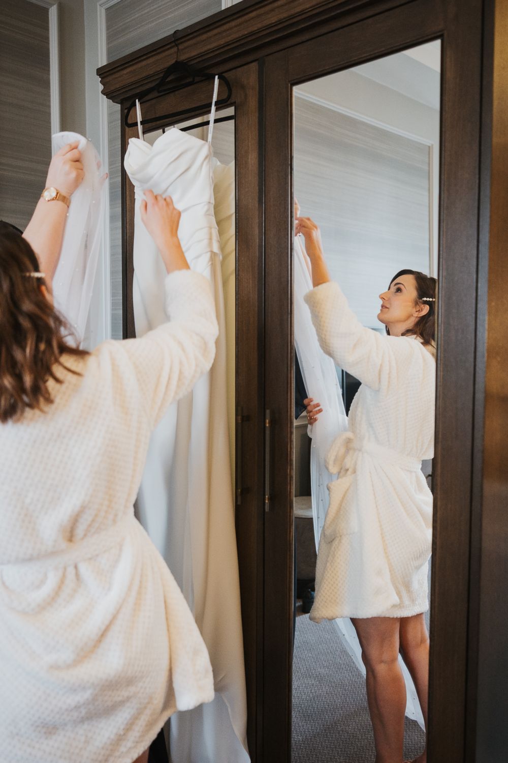 Person in white sweater robe looking up while facing dark wooden wardrobe in sequence of repeated photos.
