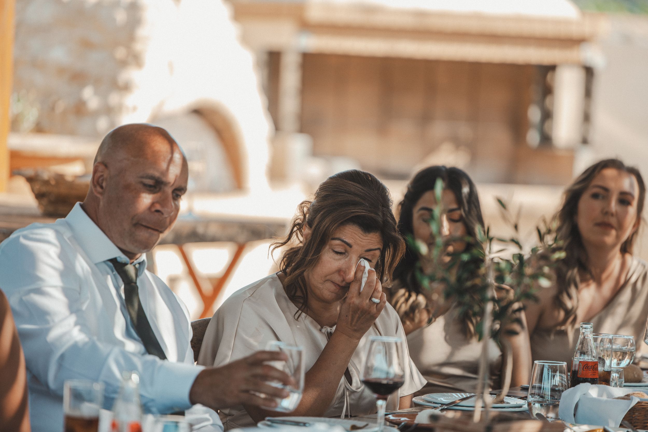 Wedding reception guests dining and conversing at elegant tables.