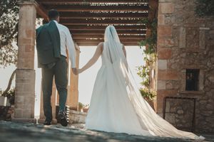 Wedding couple and guests celebrating under stone archway with string lights.