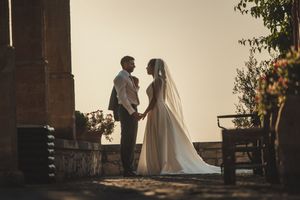 Silhouetted wedding couple standing in romantic backlit setting.