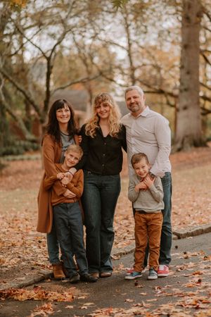 Several playful family photos captured on a path covered in fallen autumn leaves.