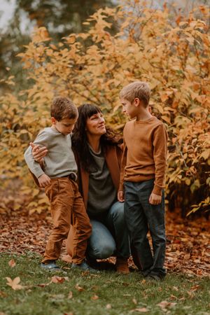 A tender family moment captured among golden fall leaves and autumn colors.