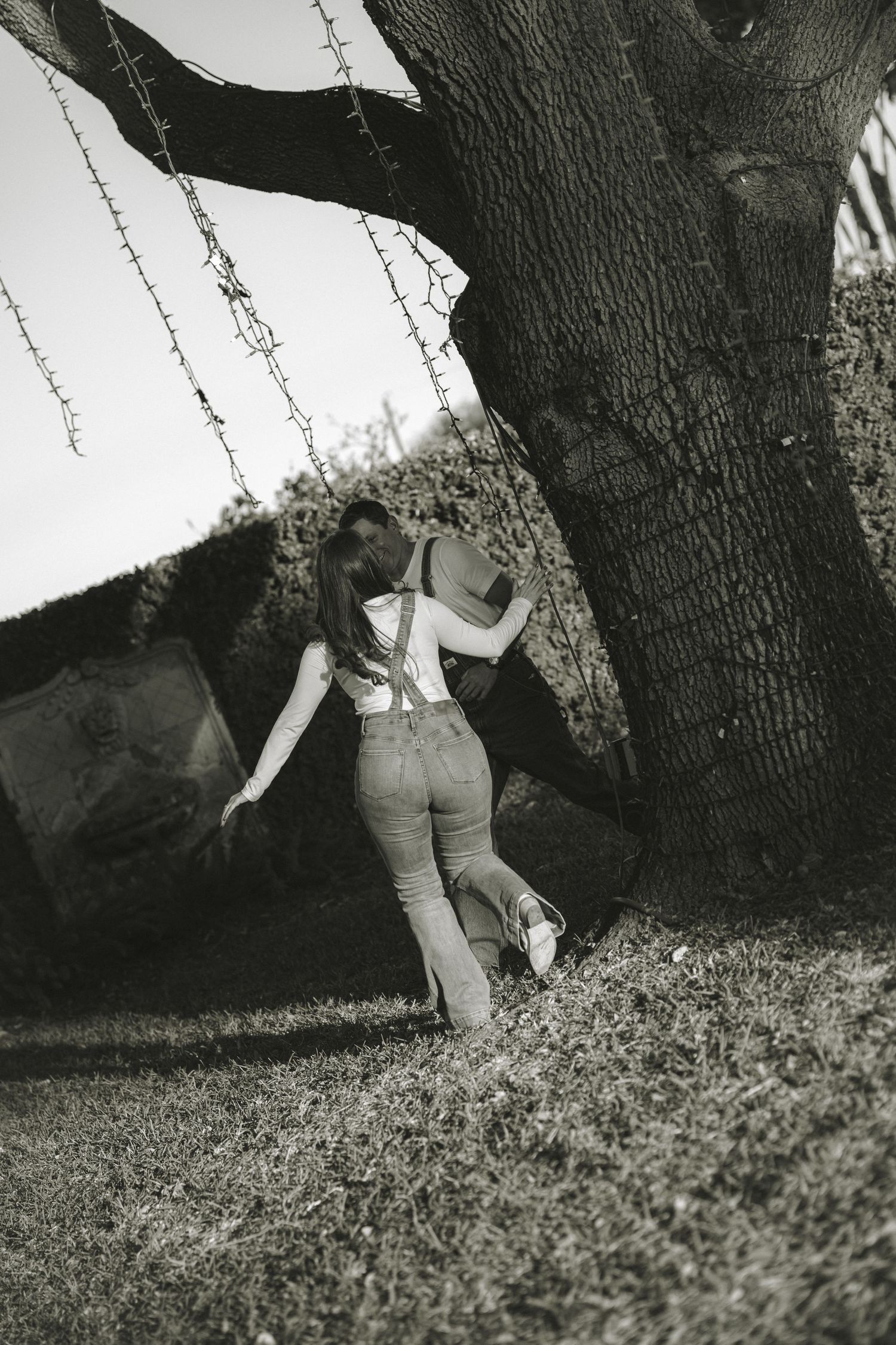 Black and white photo sequence of a couple lying together under a large tree.