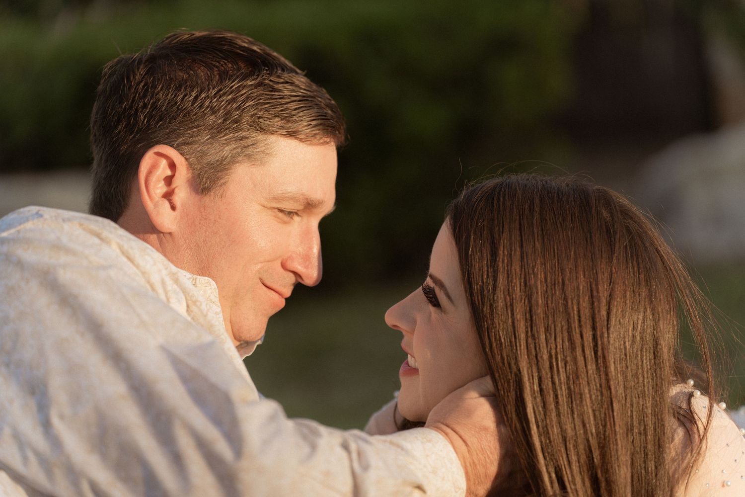 Sunset engagement photos showing couple laughing and embracing in natural light.