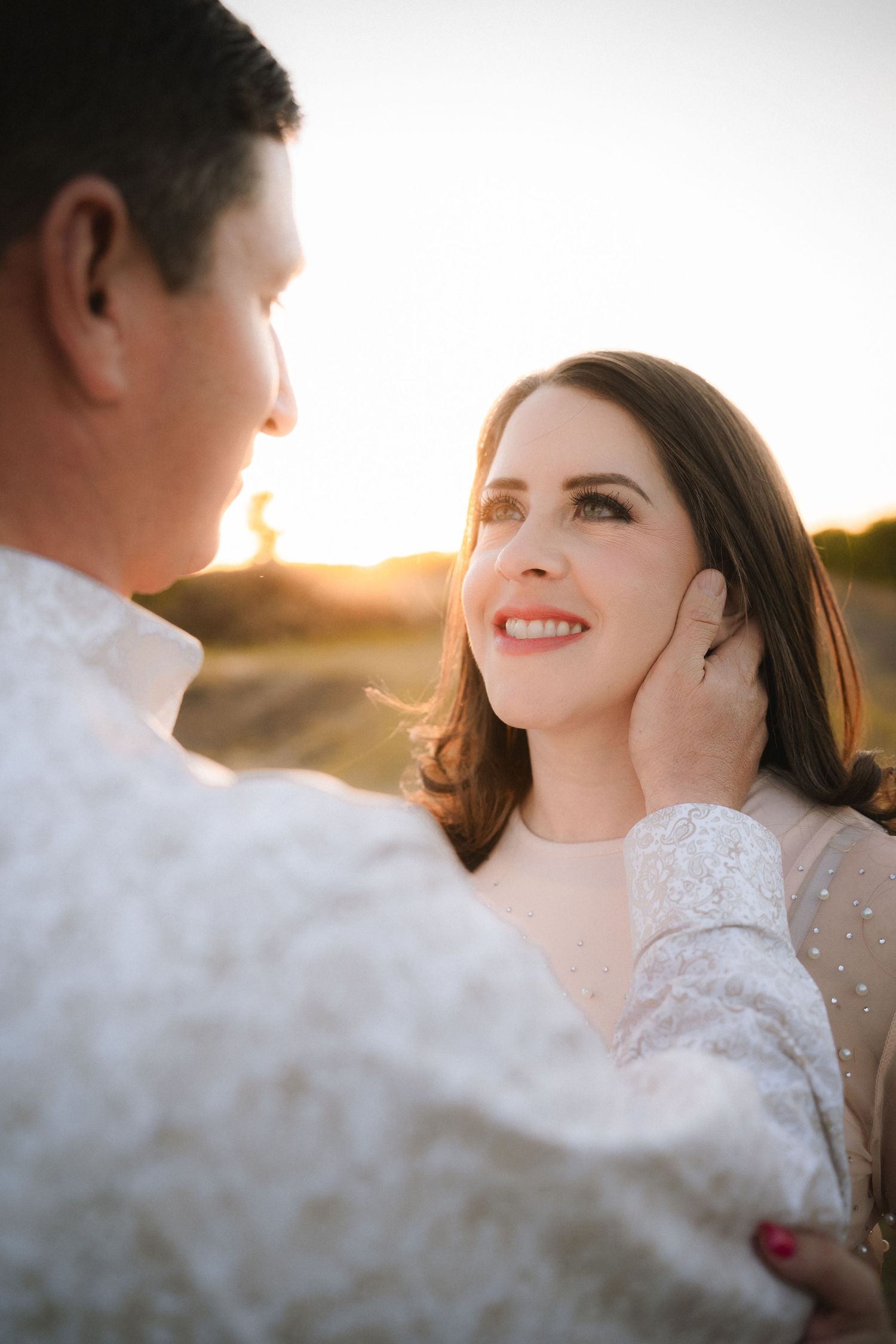 Close-up romantic portraits of couple during sunset with soft natural lighting.