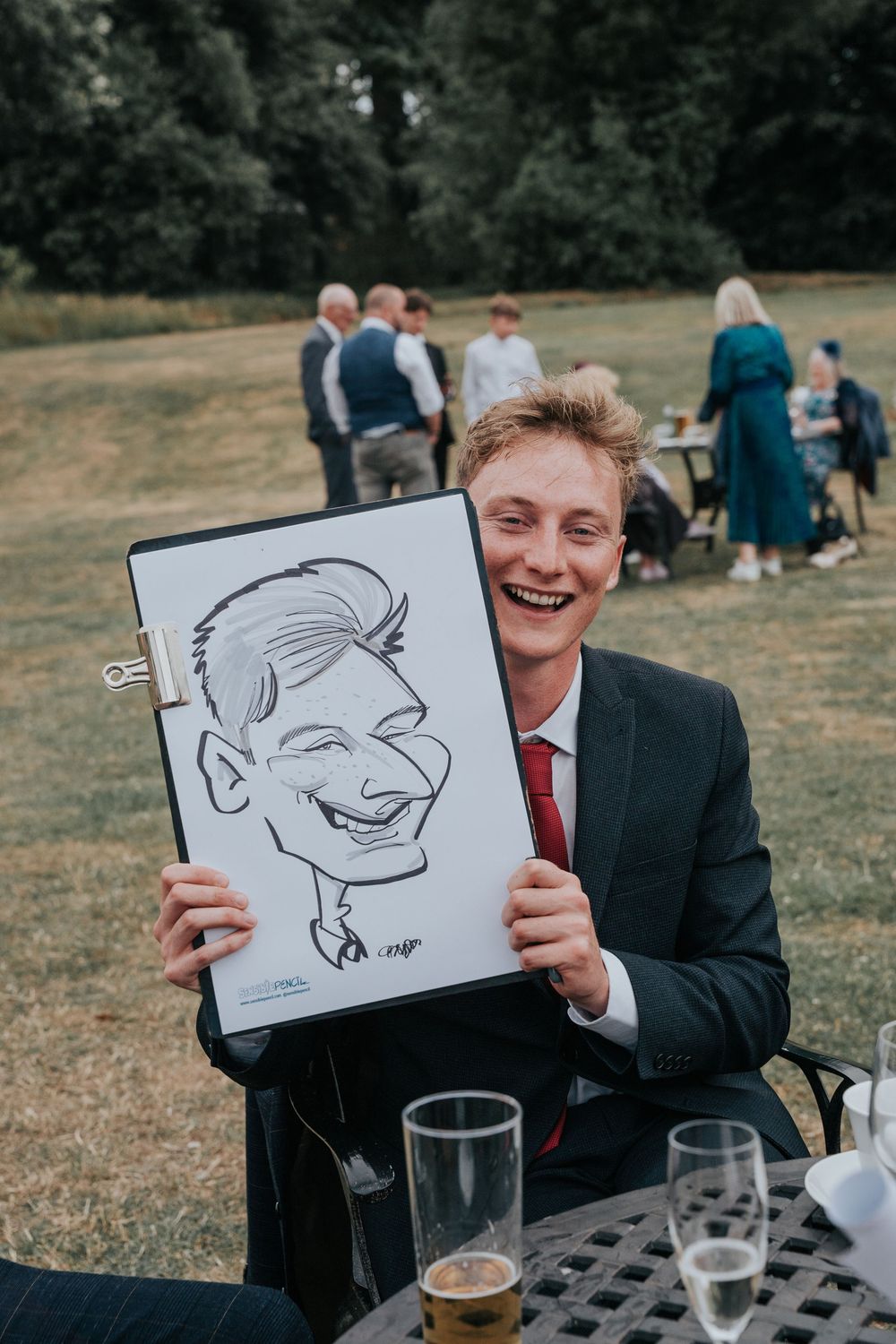 Caricaturist from Sensible Pencil drawing wedding guests outdoors