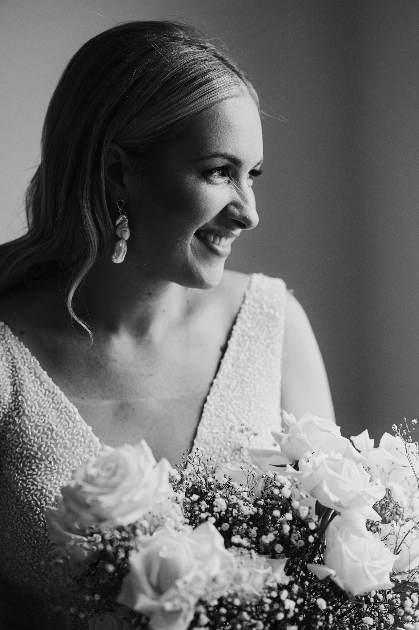 Artistic black and white portraits featuring bridal details and white rose bouquet.