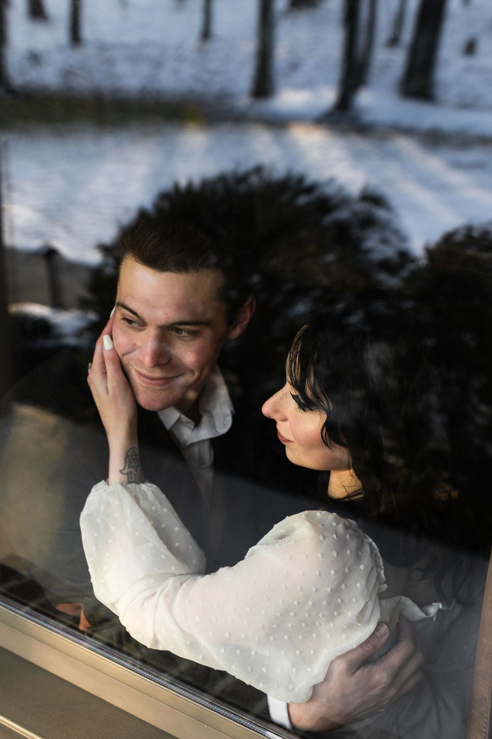 An artistic winter wedding photoshoot sequence with reflective window elements.