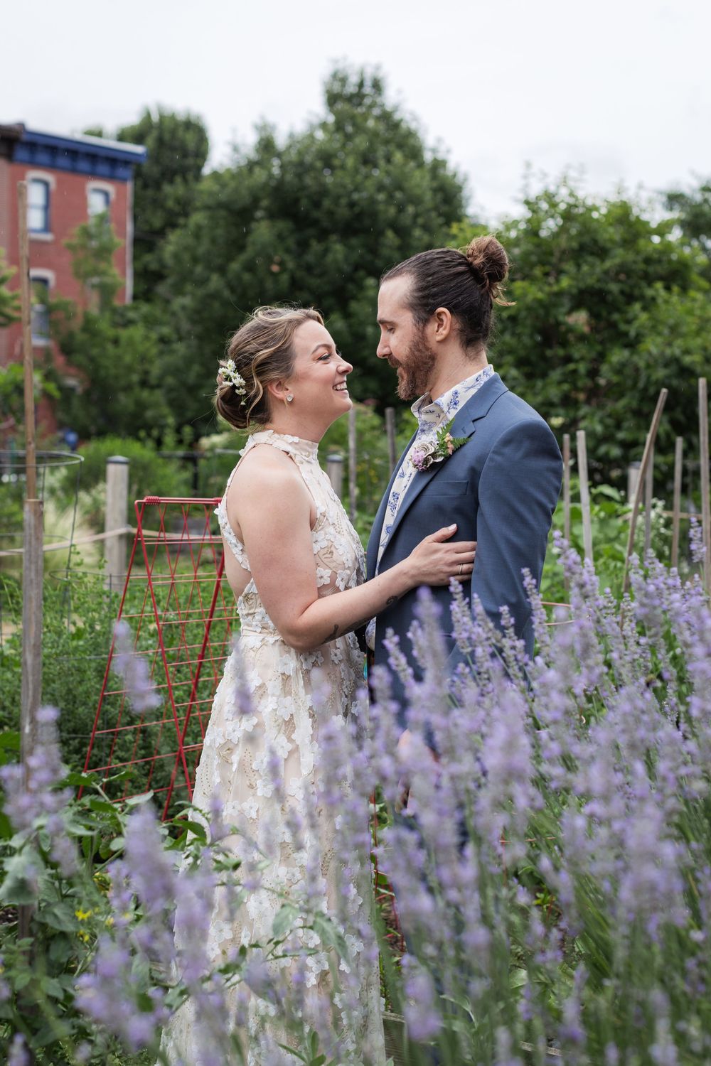 Couple shares joyful moment among blooming purple lavender in garden at Eastern State Penitentiary.