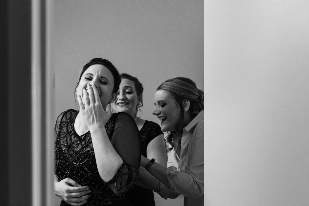 An emotional black and white candid moment shared between wedding attendees.