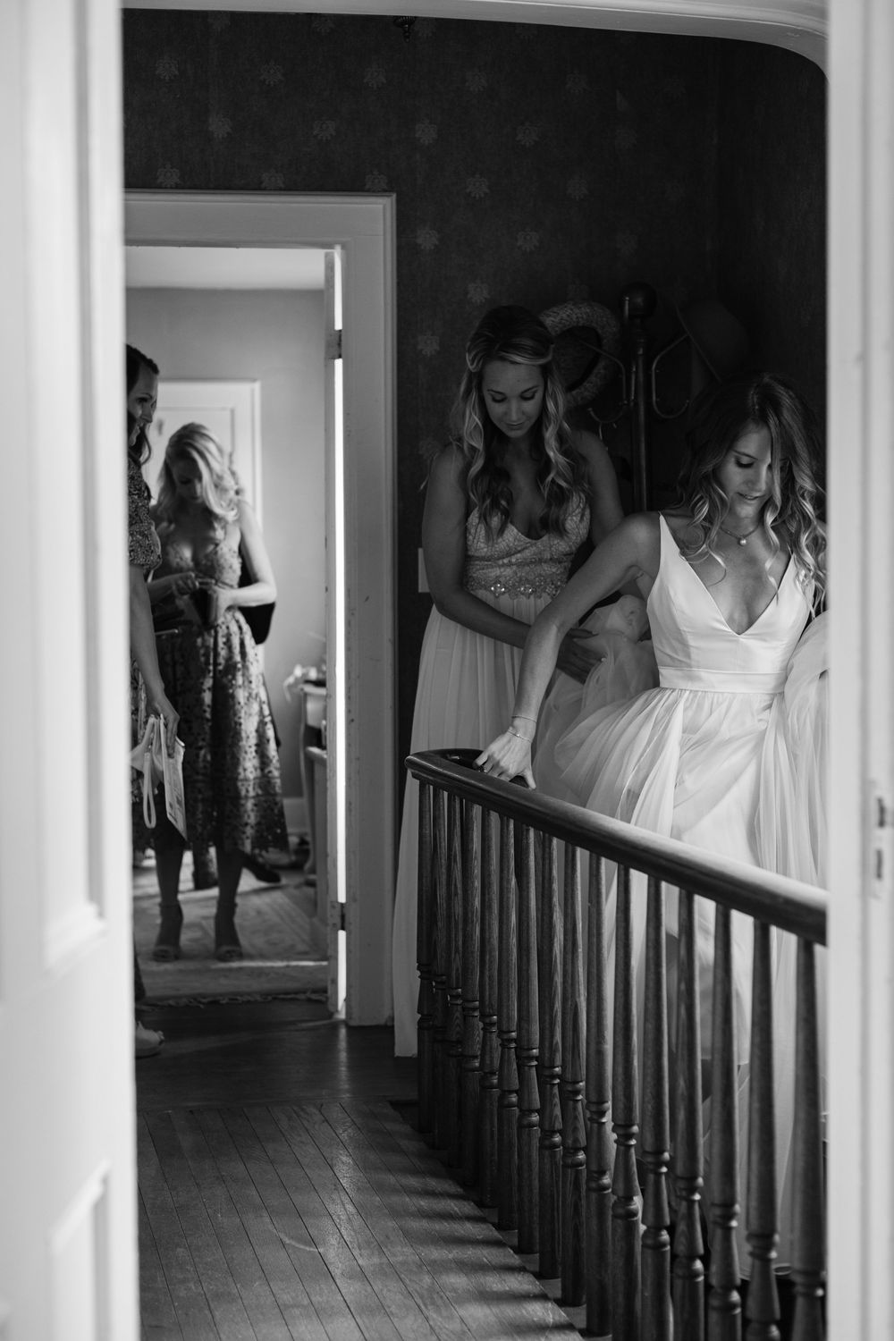 Black and white photograph of a hallway with wooden banisters and dramatic lighting.