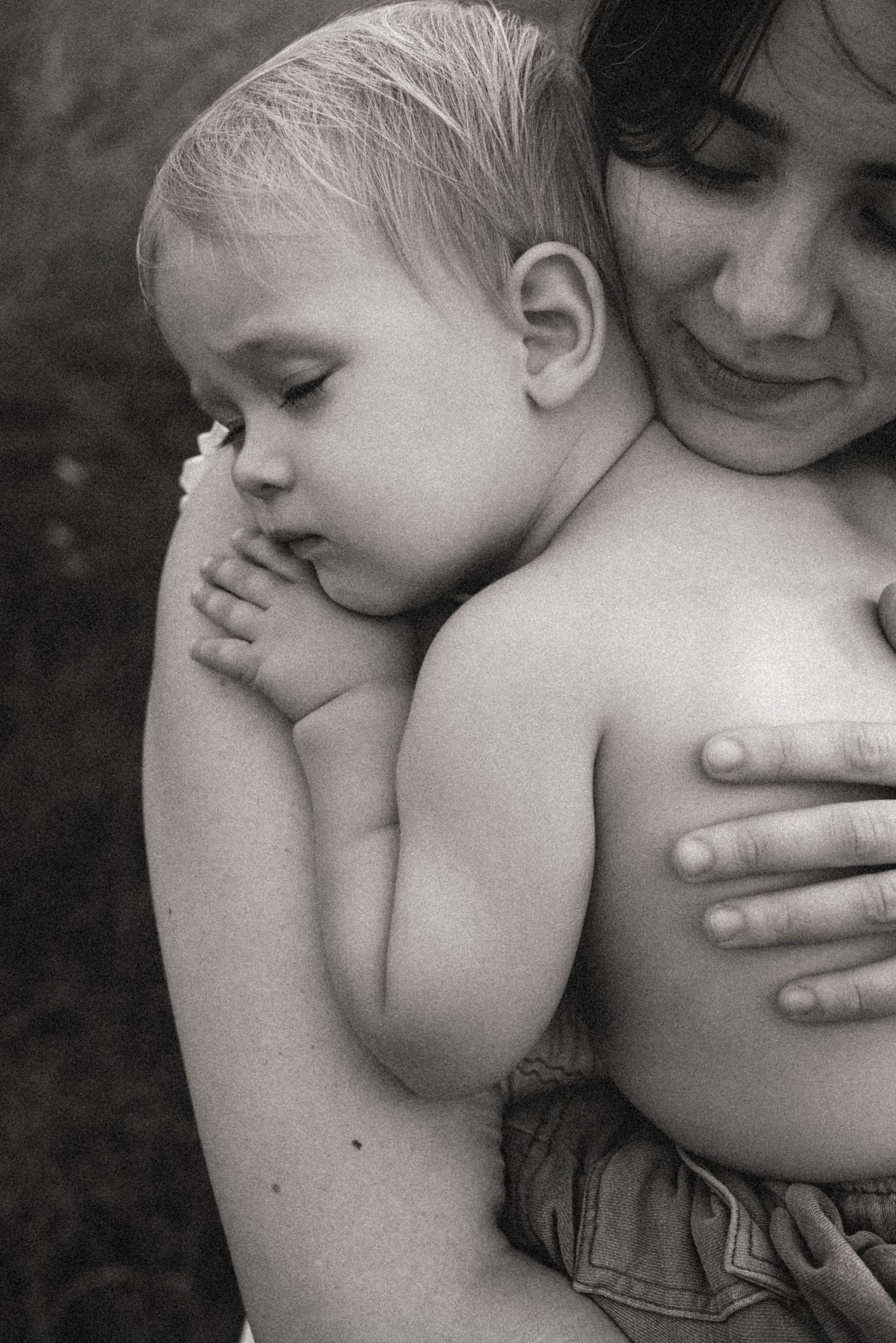 A black and white photo series showing tender affectionate moments between a young child and caregiver. Javea photographer