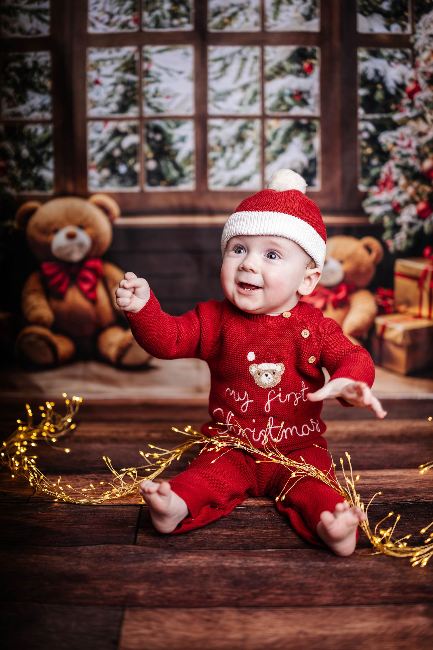 A child wearing a Santa hat looks joyfully at a decorated Christmas tree through a frosty window. Christmas mini shoot, Southport