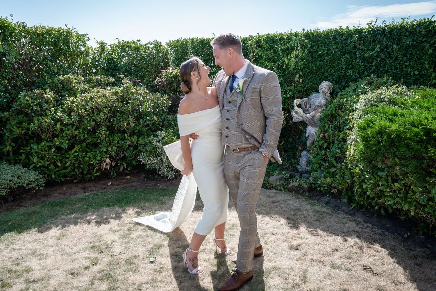 A couple in wedding attire shares a romantic dance together in a lush garden setting on their special day.