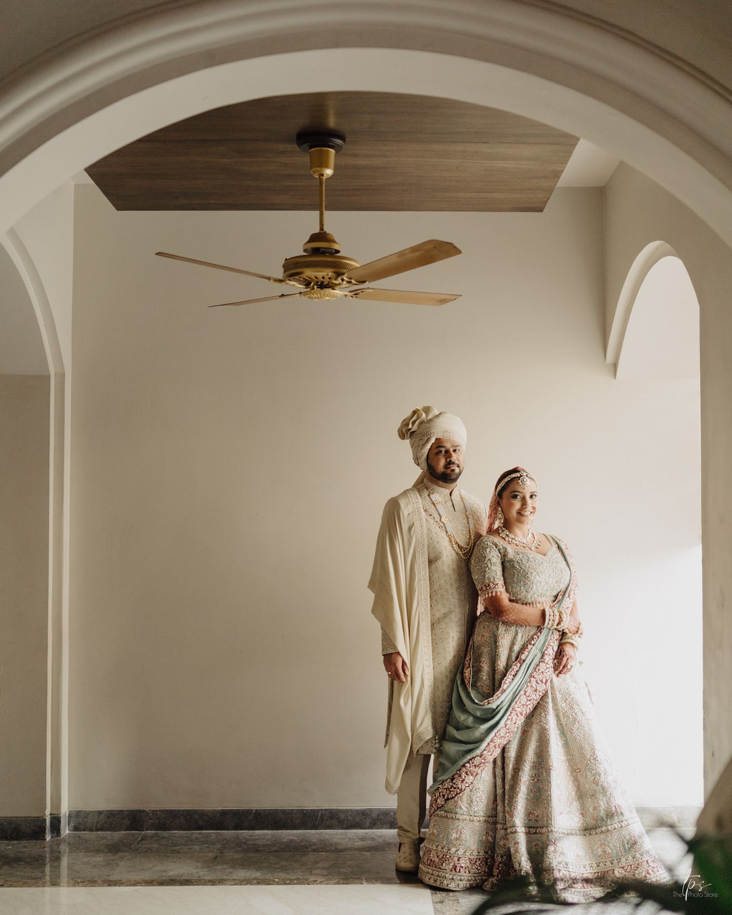 Elegant wedding couple under a white arched ceiling, beautifully framed by a top wedding photographer in Mumbai near me.