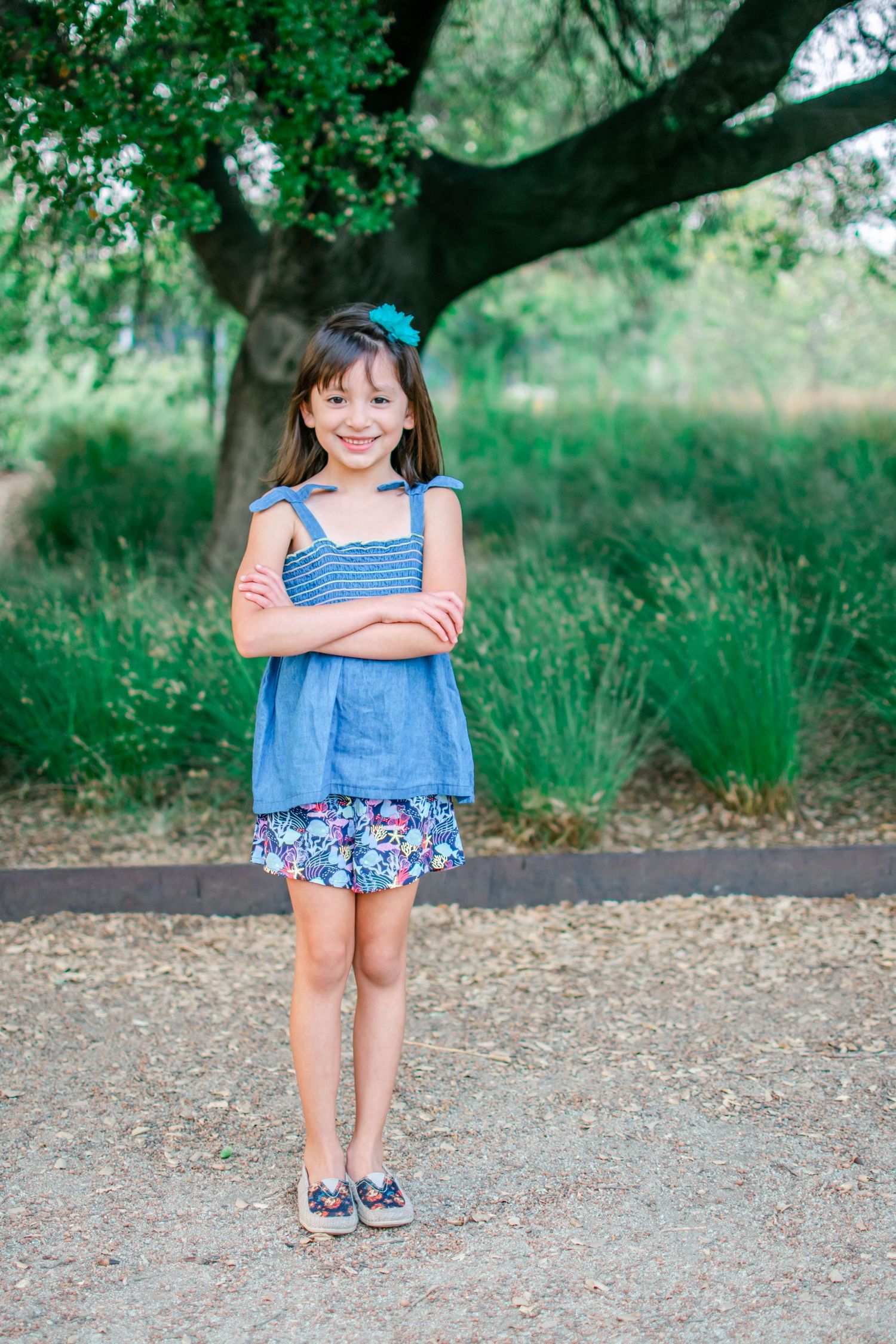 A series of outdoor photos showing a child in a blue summer dress posing playfully against a natural backdrop.