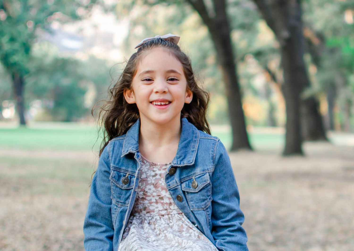 Outdoor portrait series featuring denim jacket and casual poses in a park setting.