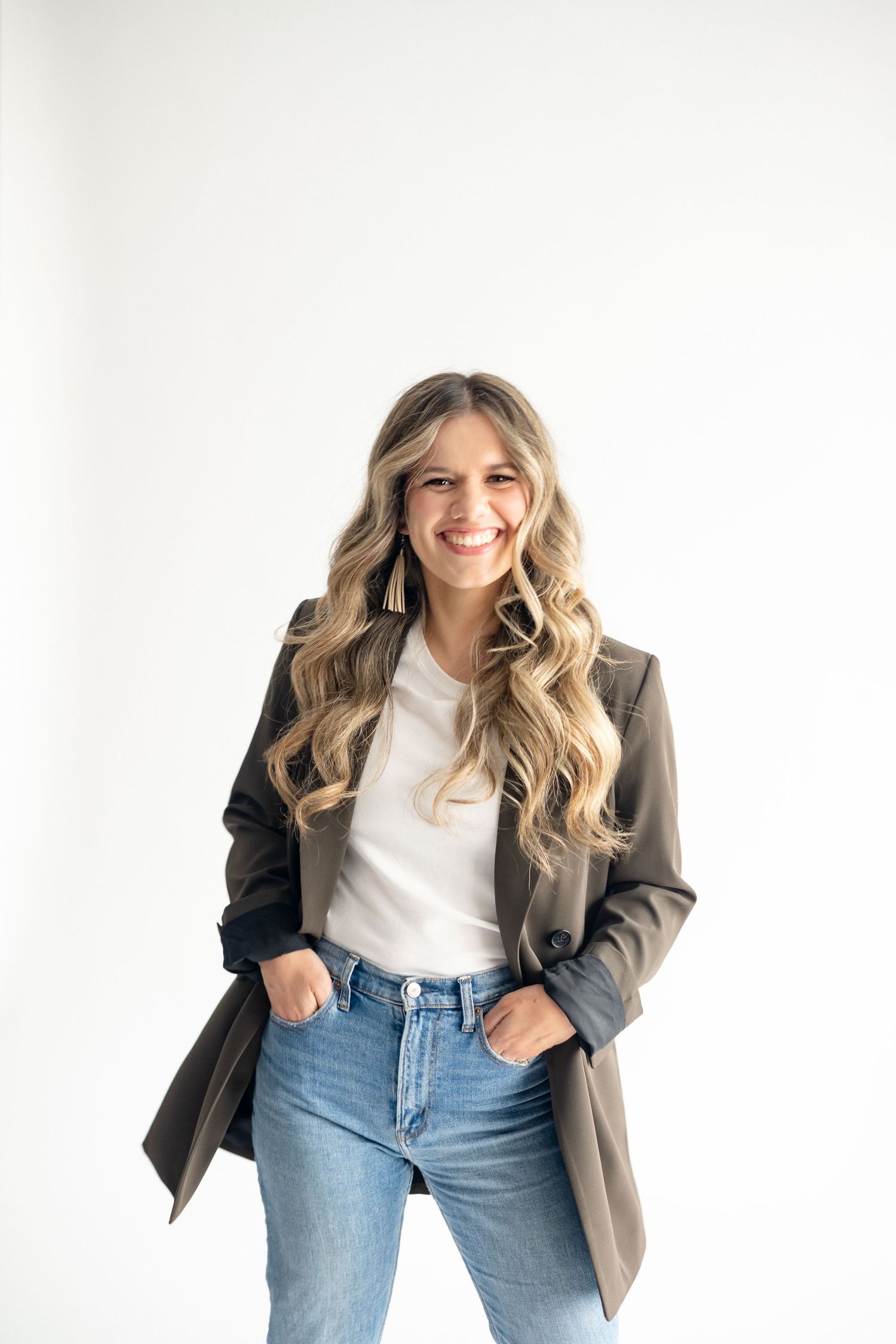 Branding photo of woman in blazer and jeans against white background.