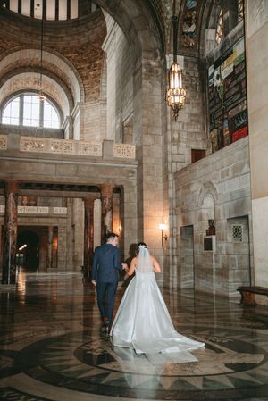 A wedding photoshoot in an ornate stone interior with arched ceilings and decorative floor patterns.
