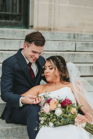 A romantic moment on stone steps with a beautiful floral bouquet.